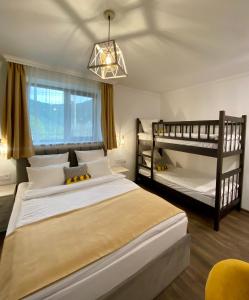 a bedroom with two twin beds and a chandelier at Aurelia Hotel & Restaurant in Dilijan