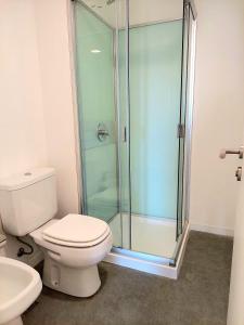 a bathroom with a toilet and a glass shower at Moderno Apartamento #1 Excelente ubicación in Punta del Este