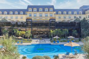 a hotel with a pool in front of a building at Renaissance Cairo Mirage City Hotel in Cairo