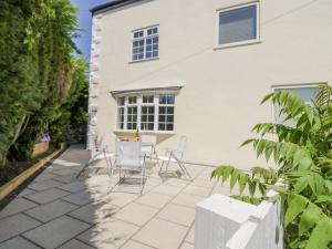 a patio with chairs and a table in front of a building at The Cottage in Barrow in Furness