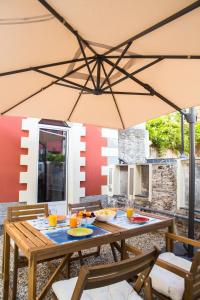a picnic table with an umbrella on a patio at La CASETTA Antica dimora nel centro storico in Chiavari
