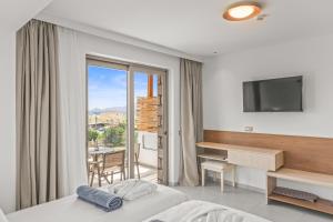 KOUROS STONE SUITES في شاراكي: غرفة في الفندق مع سرير ومكتب