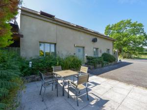ein Tisch und Stühle vor einem Haus in der Unterkunft Oak Leaves Cottage in Newton Abbot