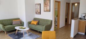 una sala de estar con 2 sofás verdes y una mesa. en Apartments in Krk, en Krk