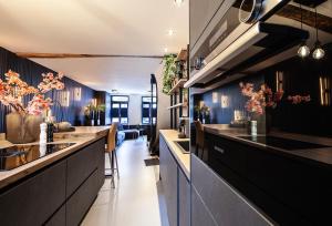 a kitchen with black cabinets and a long counter at Chambers Roermond in Roermond