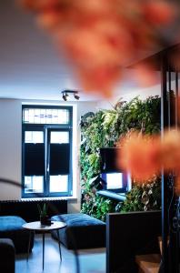 a room with a green wall with couches and a table at Chambers Roermond in Roermond