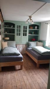 two beds in a room with green walls at Historisches Fachwerkhaus "Hoher Hirschen" mit eigenem Hof und Garten - Charmantes, kleineres Studio und museales Apartment in Bodman-Ludwigshafen