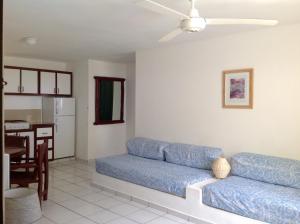 a living room with a blue couch and a kitchen at La Punta Apartamentos in Cabarete