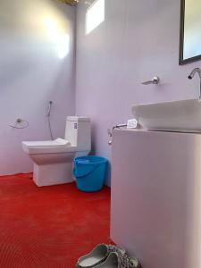 a bathroom with a sink and a toilet and red floor at Mentsel Merak Pangong in Kakstet