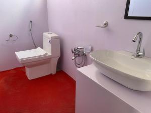 a bathroom with a white sink and a toilet at Mentsel Merak Pangong in Kakstet