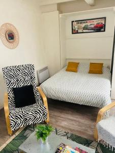 uma sala de estar com duas camas e uma cadeira em Bienvenue chez vous au Panier ! Appartement classé 1 étoile em Marselha