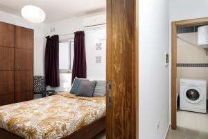- une chambre avec un lit et un lave-linge dans l'établissement Hilltop Apartments - Stylish Comfort Living close to the sea, Bugibba, à San Pawl il-Baħar