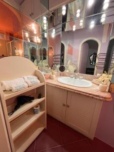 ein Badezimmer mit einem Waschbecken und einem großen Spiegel in der Unterkunft Casa al Duomo in Taormina