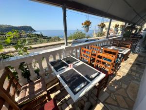 een tafel en stoelen op een balkon met uitzicht op de oceaan bij Lazaris kwstas Rooms in Himare