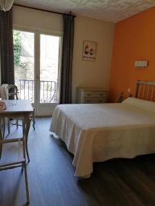 Schlafzimmer mit einem Bett, einem Tisch und einem Fenster in der Unterkunft HOTEL AMBEILLE in Collioure