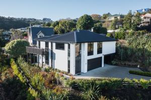 an aerial view of a white house with a garage at Modern family friendly getaway in Dunedin