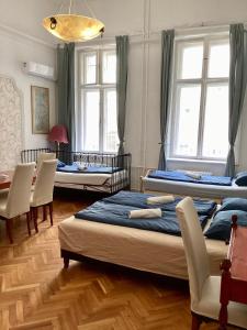 a bedroom with two beds and a table and chairs at Central Apartments of Budapest in Budapest