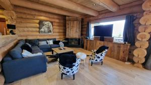 a living room with a couch and a table and chairs at Chalet Nanook, charme et luxe Pyrénéen in Bolquere Pyrenees 2000