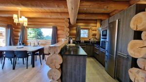a kitchen with wooden walls and a table with chairs at Chalet Nanook, charme et luxe Pyrénéen in Bolquere Pyrenees 2000