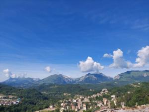 vistas a una ciudad con montañas en el fondo en Rustico Via del Sole 13, en Amandola