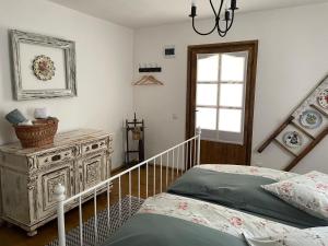 a bedroom with a bed and a dresser and a window at La Novaci Porumbacu de Sus 270 in Porumbacu de Sus