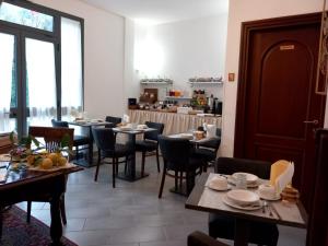 un comedor con mesas, sillas y ventanas en camere Caterina, en Bonassola