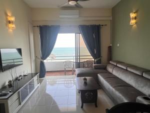 a living room with a couch and a view of the ocean at Tanjung Tuan Regency Port Dickson 1 CarPark in Port Dickson