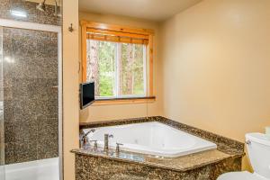 Ronald的住宿－Moose Lodge，带浴缸、卫生间和窗户的浴室