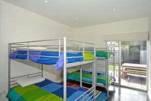 2 Etagenbetten in einem Zimmer mit Balkon in der Unterkunft 120 Seagull Hayborough - BYO Linen - Wi-Fi Beach Pet Friendly in Hayborough