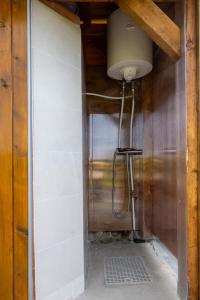 ein Bad mit einer Dusche mit einem Licht an der Wand in der Unterkunft Apiary at Klemen's in Črni Vrh