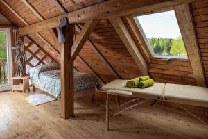 ein Schlafzimmer in einem Blockhaus mit einem Bett und einem Fenster in der Unterkunft Apiary at Klemen's in Črni Vrh