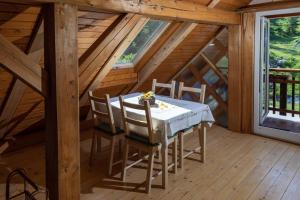 ein Esszimmer mit einem Tisch und Stühlen in einer Hütte in der Unterkunft Apiary at Klemen's in Črni Vrh