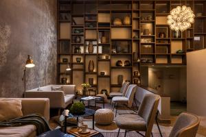 a lobby with couches and chairs and a wall of shelves at Hotel Terme Jezercica in Donja Stubica