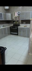 a kitchen with white tile floors and a stove at شقة مفروشه ب٣ غرف in Sūq al Aḩad