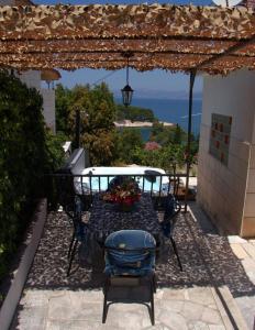 patio ze stołem i krzesłami pod pergolą w obiekcie Seaview Residence w mieście Splitska