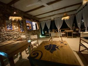 Ocean Breeze Boutique Hotel في نونغوي: غرفة طعام مع طاولة وكراسي خشبية
