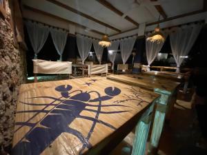 un grande tavolo in legno con un dipinto sopra di Ocean Breeze Boutique Hotel a Nungwi