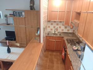 Una pequeña cocina con gabinetes de madera y un fregadero. en La Pergola, en Bellano