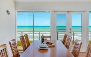 a dining room with a table and a view of the ocean at 124 Surfers Pde - BYO Linen Beachfront in Middleton +30 photos
