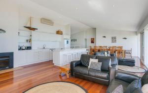 a living room with a couch and a kitchen at 124 Surfers Pde - BYO Linen Beachfront in Middleton