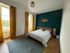 um quarto com uma cama e uma parede verde em La Maison des Amis en Normandie em Pontfarcy