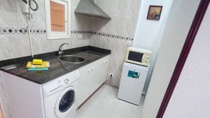 małą kuchnię ze zlewem i pralką w obiekcie apartamento abuhardillado w mieście Cuchia +9 zdjęć