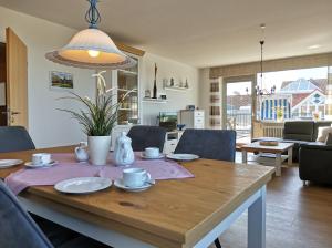 a dining room and living room with a wooden table at Hallenbad Wohnung in Neuharlingersiel