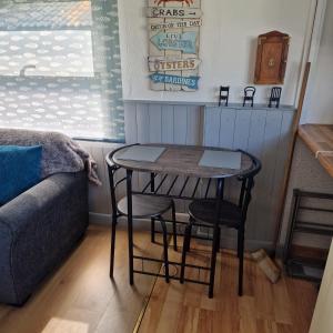 a small table and chairs in a room with a couch at Chalet 88 in Aberystwyth