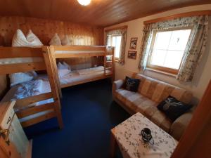 a room with two bunk beds and a couch at Haus zur Kapelle in Sankt Gallenkirch