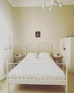 un letto bianco in una stanza con due tavoli di Casa Elvira a Tuglie
