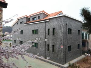 un gran edificio con árboles akuraakura delante de él en Hub Guest House en Incheon