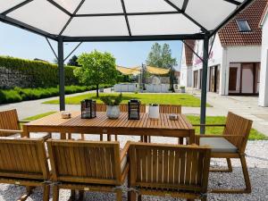 una mesa de madera y sillas bajo un cenador en Hotel Marcincak***, en Mikulov