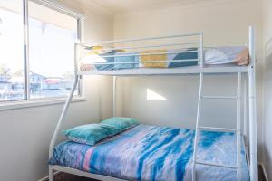 a bedroom with a bunk bed and a window at Cockatoo House in Sussex inlet