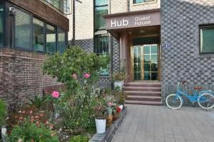 un vélo bleu garé devant un bâtiment en briques dans l'établissement Hub Guest House, à Incheon